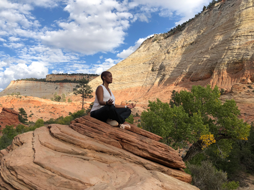 Retha meditating outdoors.