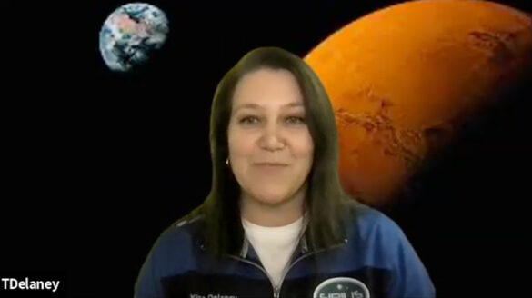 Dr. Tetyana Delaney during a virtual meeting, with a backdrop of Mars and Earth behind her.