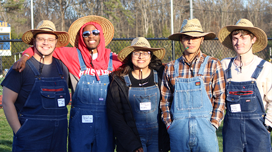 A team wearing overalls and cowboy hats waiting to compete in Field Day.