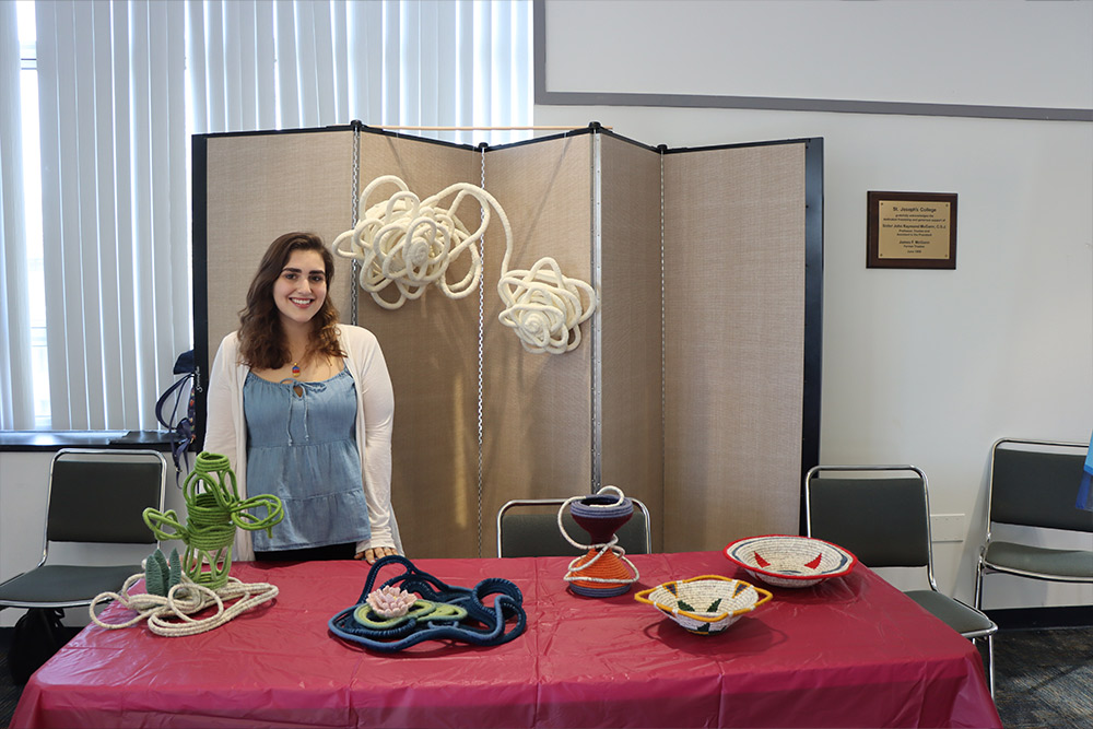 Student with artwork at the Student Research Symposium.
